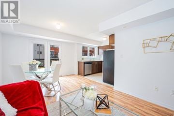Oakville (Ro River Oaks) townhouse for rent - A modern living room with a glass table and a red chair.