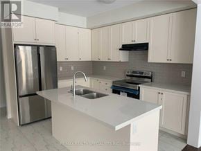 Brantford apartment for rent - A kitchen with white cabinets and a stainless steel refrigerator.