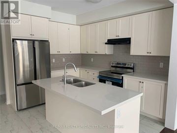 Brantford apartment for rent - A kitchen with white cabinets and a stainless steel refrigerator.