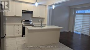 Brantford apartment for rent - A kitchen with white cabinets and a white island with a sink.