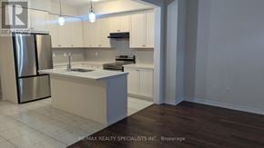 Brantford apartment for rent - A modern kitchen with white cabinets and a stainless steel refrigerator.