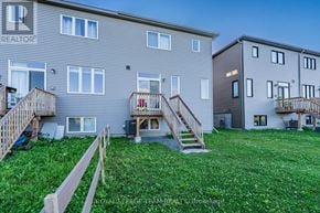 Ottawa townhouse for rent - A grassy area in front of two apartment buildings with wooden railings.