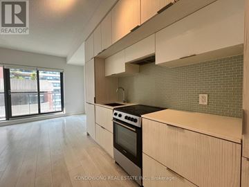 Toronto (Church-Yonge Corridor) condo for rent - A kitchen with white cabinets and a black stove top oven.