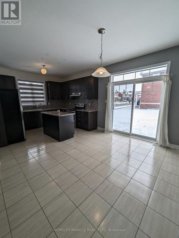 Collingwood apartment for rent - A spacious kitchen with black cabinets and a large island.