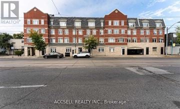 Toronto (Long Branch) townhouse for rent - A large red brick building with the words REALTOR® on the top left corner.