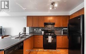 Toronto (Long Branch) townhouse for rent - A kitchen with wooden cabinets and a black refrigerator.