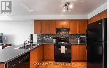 Toronto (Long Branch) townhouse for rent - A kitchen with wooden cabinets and a black refrigerator.