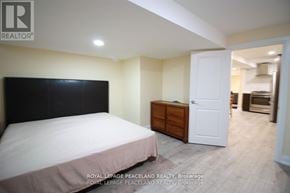 Oakville (Ga Glen Abbey) apartment for rent - A bedroom with a bed, dresser, and open door to a kitchen.
