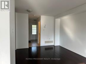Brantford townhouse for rent - A room with white walls and a wooden floor.