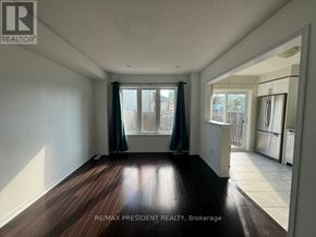 Brantford townhouse for rent - A room with wooden floors and white walls, with a window and a door visible.