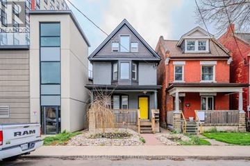 Hamilton (Beasley) duplex for rent - A grey house with a yellow door is in the middle of two other houses.