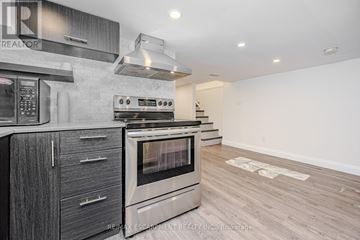 Hamilton (Beasley) multi-family for rent - A modern kitchen with a stainless steel oven and wooden cabinets.
