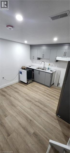Kitchener apartment for rent - A kitchen with a refrigerator, sink, and cabinets.