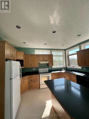 Guelph (Pineridge/Westminster Woods) apartment for rent - A kitchen with white appliances and wooden cabinets.