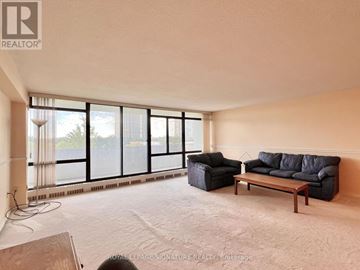 Toronto (Don Valley Village) condo for rent - A living room with a couch, chair, and large windows.