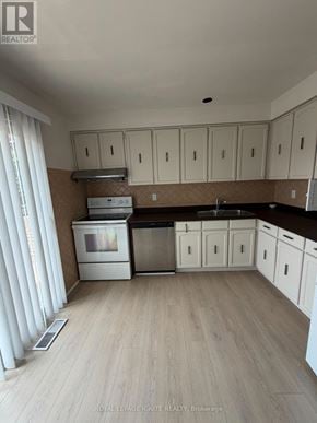 Toronto (Agincourt North) townhouse for rent - A kitchen with white cabinets and a black countertop.