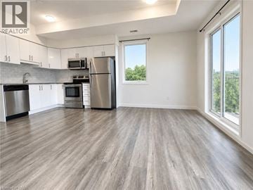 Kitchener townhouse for rent - A kitchen with a refrigerator, oven, and microwave.