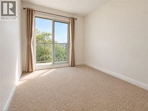 Kitchener townhouse for rent - A room with a carpeted floor and a large window with curtains.