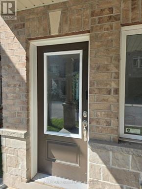 Hamilton (Winona Park) townhouse for rent - A brown door with a glass window is on a brick wall.