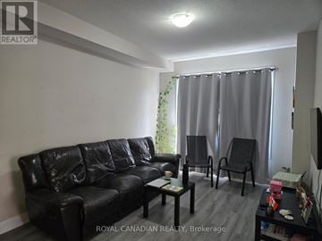 Hamilton (Winona Park) townhouse for rent - A living room with a black leather couch and a coffee table.