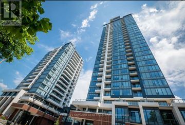 Kitchener house for rent - Two tall buildings with glass windows and balconies are under a blue sky with clouds.