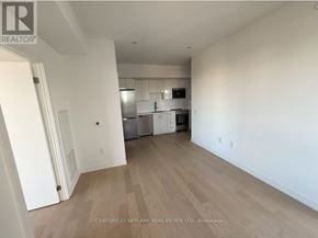Kitchener house for rent - A spacious kitchen and living room with white walls and wooden flooring.