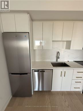 Kitchener house for rent - A kitchen with a stainless steel refrigerator and white cabinets.