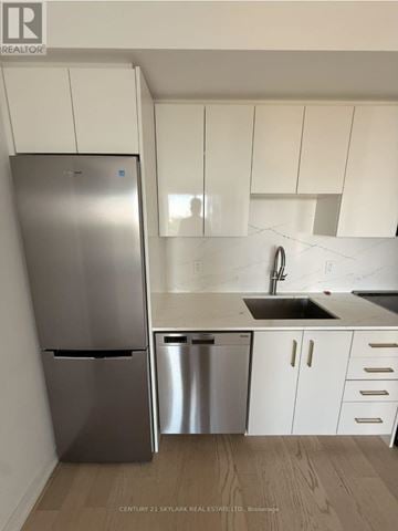Kitchener house for rent - A kitchen with a stainless steel refrigerator and white cabinets.