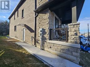 Pickering apartment for rent - A kitchen with white cabinets and a black fridge.
