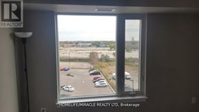 Milton (Tm Timberlea) condo for rent - A window with a view of a parking lot and buildings outside.