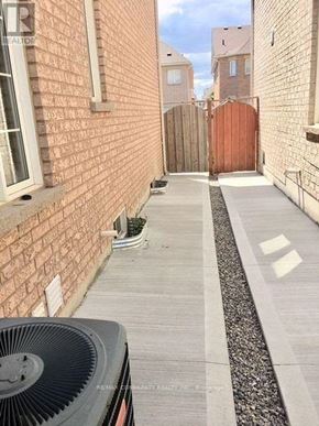 Markham (Box Grove) apartment for rent - A narrow alley with a brick wall on one side and a wooden fence on the other.