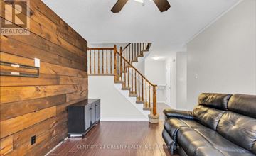Hamilton (Stoney Creek) apartment for rent - A living room with a leather couch and a wooden wall.