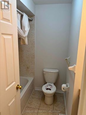 Whitby (Taunton North) townhouse for rent - A small bathroom with a toilet and a bathtub.