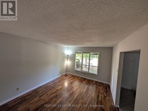 London South (South X) apartment for rent - A room with wooden floors and a window with a view of trees.