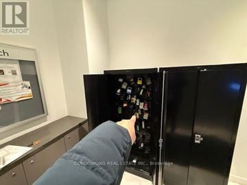 Toronto (Church-Yonge Corridor) house for rent - A person is opening a black vending machine.