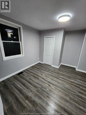 Windsor apartment for rent - A room with a wooden floor and a white door.