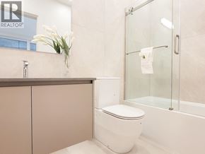 West Vancouver apartment for rent - A white toilet sits in a bathroom with a glass shower door.