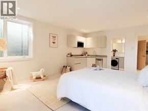 West Vancouver apartment for rent - A bedroom with a bed, a chair, and a small dog toy.