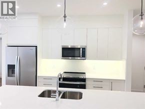 Calgary apartment for rent - A modern kitchen with white cabinets and stainless steel appliances.