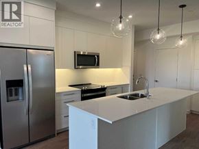 Calgary apartment for rent - A modern kitchen with a white countertop and stainless steel appliances.
