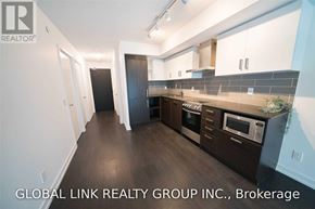 Toronto (Mount Pleasant West) condo for rent - A modern kitchen with dark wood floors and white walls.