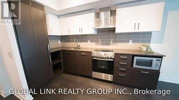 Toronto (Mount Pleasant West) condo for rent - A kitchen with brown cabinets and a white microwave.