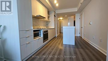 Toronto (Waterfront Communities) condo for rent - A modern kitchen with white cabinets and a white refrigerator.