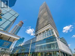 Toronto (Waterfront Communities) condo for rent - A tall building with a glass facade stands in front of a construction site.