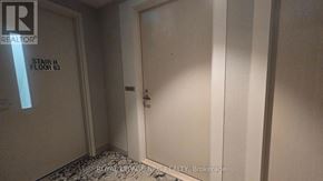Toronto (Waterfront Communities) condo for rent - A hallway with a door and a sign that says "Stair H Floor 63".