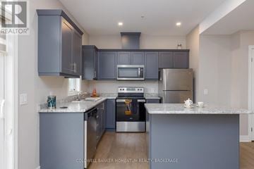 St. Catharines (Oakdale) townhouse for rent - A modern kitchen with a stainless steel refrigerator and oven.