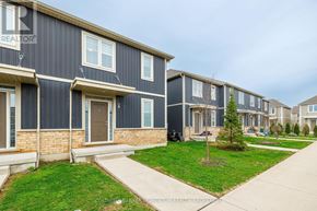 St. Catharines (Oakdale) townhouse for rent - A row of houses with the front of one visible showing a door and a small tree.