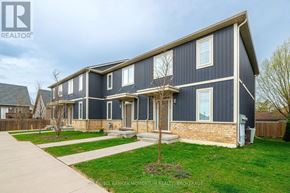 St. Catharines (Oakdale) townhouse for rent - A blue house with a white window and a tree in front.