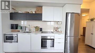 Toronto (Islington-City Centre West) condo for rent - A modern kitchen with white cabinets and stainless steel appliances.