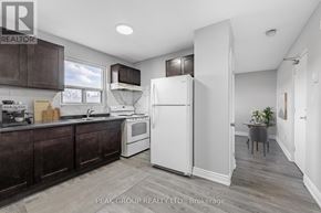 Welland (Lincoln/Crowland) multi-family for rent - A kitchen with dark brown cabinets and a white refrigerator.